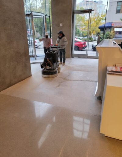two person is under progress of polishing the floor