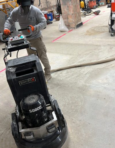 A man is using a floor scrubber in a warehouse