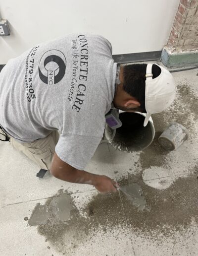 A man in a white hat working on a floor