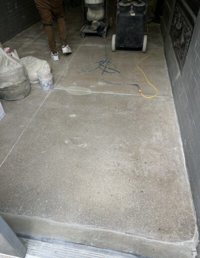 A man standing in a garage with a vacuum on the floor